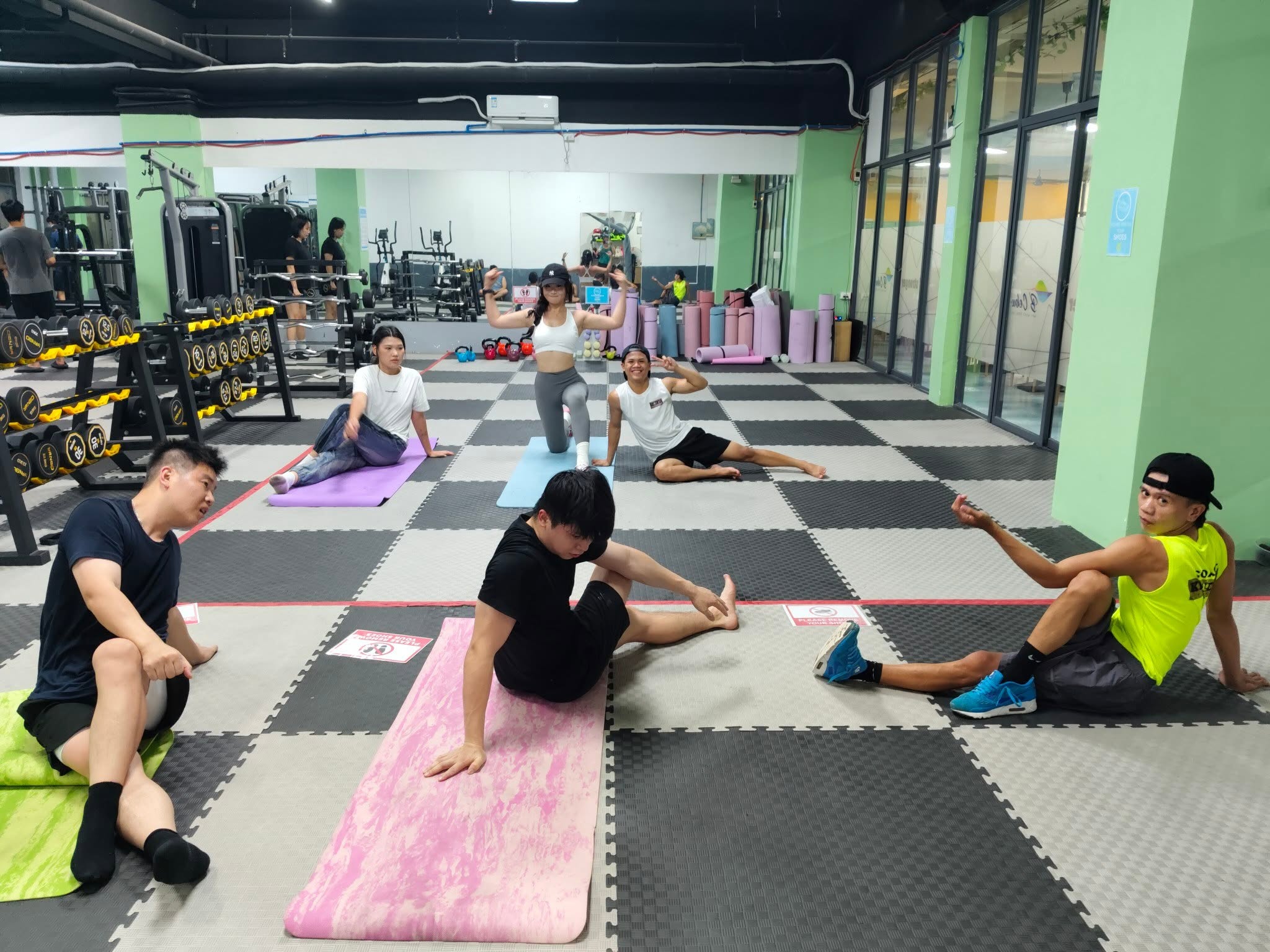 Members stretching together on the gym mats